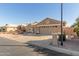 Tan two-story house with a three-car garage and desert landscaping at 15491 W Amelia Dr, Goodyear, AZ 85395