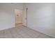 Simple bedroom with tile floors and a door leading to another room at 16796 W Pierce St, Goodyear, AZ 85338