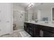Bathroom featuring double sinks, modern cabinets, tile flooring, and a walk-in shower with glass doors at 1921 E Lantana Dr, Chandler, AZ 85286