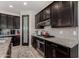 Modern kitchen featuring dark cabinets, granite countertops, stainless steel appliances, and tile flooring at 1921 E Lantana Dr, Chandler, AZ 85286