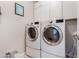 Laundry room with modern washer and dryer units and overhead cabinets for ample storage at 1921 E Lantana Dr, Chandler, AZ 85286