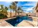 Backyard pool with a water feature and desert landscaping surrounded by a tan stucco wall at 1921 E Lantana Dr, Chandler, AZ 85286