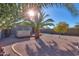 Sunny backyard with gravel, a hot tub, and palm trees at 19572 N Sandalwood Dr, Maricopa, AZ 85138