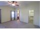 Main bedroom with neutral carpeting, ceiling fan and walk-in closet at 19572 N Sandalwood Dr, Maricopa, AZ 85138