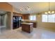 Kitchen with dark wood cabinets, black appliances, and an island at 19572 N Sandalwood Dr, Maricopa, AZ 85138