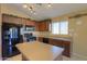 Modern kitchen with dark wood cabinets, black appliances and an island at 19572 N Sandalwood Dr, Maricopa, AZ 85138