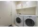 Laundry room with washer, dryer, and overhead cabinets at 19572 N Sandalwood Dr, Maricopa, AZ 85138