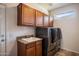 Well-equipped laundry room with washer, dryer, cabinets, and sink at 20188 N Sojourner Dr, Surprise, AZ 85387