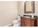 Stylish half-bathroom with dark wood vanity and granite top at 2562 N 169Th Ave, Goodyear, AZ 85395