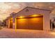 Evening view of a two-car garage with brick paver driveway at 2562 N 169Th Ave, Goodyear, AZ 85395