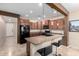 Modern kitchen with dark wood cabinets, granite countertops, and black appliances at 25823 N 122Nd Ln, Peoria, AZ 85383