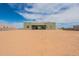 Back exterior of the home with desert landscaping and a large, partially covered patio at 29340 N 231St Ave, Wittmann, AZ 85361