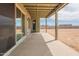 Covered back porch with sliding glass door access overlooks a large desert landscape at 29340 N 231St Ave, Wittmann, AZ 85361
