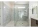 Bathroom featuring sleek glass shower with stone tile, bench, and a modern vanity with cabinet storage at 29340 N 231St Ave, Wittmann, AZ 85361