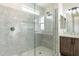 Bathroom featuring sleek glass shower with stone tile, bench, and a modern vanity with cabinet storage at 29340 N 231St Ave, Wittmann, AZ 85361
