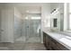 Bathroom featuring sleek glass shower with stone tile, bench, and a modern vanity with cabinet storage at 29340 N 231St Ave, Wittmann, AZ 85361