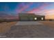 Modern home featuring a two-car garage, concrete driveway, and neutral stucco finish under a beautiful sunset sky at 29340 N 231St Ave, Wittmann, AZ 85361