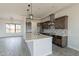 Bright, modern kitchen with an island, stainless steel appliances, tile backsplash, and pendant lighting at 29340 N 231St Ave, Wittmann, AZ 85361