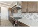 Modern kitchen with stainless steel appliances, quartz countertops, and stylish gray backsplash at 29340 N 231St Ave, Wittmann, AZ 85361