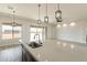Bright, modern kitchen features a large island with quartz countertop, pendant lighting, and stainless steel sink at 29340 N 231St Ave, Wittmann, AZ 85361