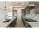 Modern kitchen with quartz countertops, stylish gray cabinets, stainless steel appliances, and geometric backsplash at 29340 N 231St Ave, Wittmann, AZ 85361
