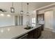 Bright modern kitchen view highlighting a large island with quartz countertop, dark cabinets, and modern pendant lighting at 29340 N 231St Ave, Wittmann, AZ 85361