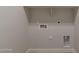 Empty laundry room hookups including water, electrical, and ventilation for a washer and dryer at 29340 N 231St Ave, Wittmann, AZ 85361