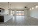 Spacious living room with sliding glass doors, tile flooring, tray ceilings, and recessed lighting at 29340 N 231St Ave, Wittmann, AZ 85361