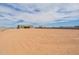 Expansive dirt lot featuring a partially built home in the distance with block wall fencing at 29340 N 231St Ave, Wittmann, AZ 85361