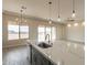 Kitchen island with sink and stainless steel dishwasher overlooking backyard and sliding glass door at 29380 N 231St Ave, Wittmann, AZ 85361