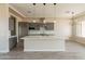 Modern kitchen features a large island, stainless steel appliances, gray cabinets, and stylish pendant lighting at 29380 N 231St Ave, Wittmann, AZ 85361