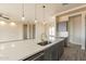 Bright kitchen island with sink and stainless steel dishwasher overlooking multiple rooms through the open concept design at 29380 N 231St Ave, Wittmann, AZ 85361