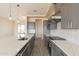 Modern kitchen features a large island with a sink, stainless steel appliances, and quartz countertops at 29380 N 231St Ave, Wittmann, AZ 85361