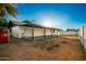 Expansive backyard with a covered patio, white brick wall, Bobcat, and ample space for outdoor activities at 3250 W Mercer N Ln, Phoenix, AZ 85029