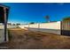 Spacious backyard enclosed by a block fence and featuring a young palm tree under a clear blue sky at 3250 W Mercer N Ln, Phoenix, AZ 85029