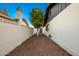 Rock-covered side yard with a small tree, white block wall, and access gate, offering a private outdoor space at 3250 W Mercer N Ln, Phoenix, AZ 85029
