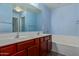 Double vanity and soaking tub in this bright bathroom at 36532 W Barcelona Ln, Maricopa, AZ 85138