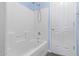 Bathroom with white tiled walls and a tub shower combo at 36532 W Barcelona Ln, Maricopa, AZ 85138