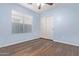 Bedroom with light blue walls, wood-look floors, and window with blinds at 36532 W Barcelona Ln, Maricopa, AZ 85138