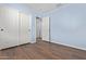 Light blue bedroom with wood-look floors and double door closet at 36532 W Barcelona Ln, Maricopa, AZ 85138