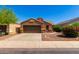 Single-story house with brown exterior, two-car garage, and landscaped front yard at 36532 W Barcelona Ln, Maricopa, AZ 85138