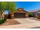 Single-story house with brown exterior, two-car garage, and landscaped front yard at 36532 W Barcelona Ln, Maricopa, AZ 85138