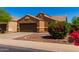 Single-story house with brown exterior, two-car garage, and landscaped front yard at 36532 W Barcelona Ln, Maricopa, AZ 85138