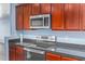 Stainless steel appliances and dark wood cabinets in kitchen at 36532 W Barcelona Ln, Maricopa, AZ 85138