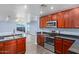 Open kitchen with island, stainless steel appliances, and view to living room at 36532 W Barcelona Ln, Maricopa, AZ 85138