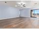 Spacious living room with light blue walls, wood-look floors, and sliding glass door at 36532 W Barcelona Ln, Maricopa, AZ 85138