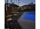 Night view of a refreshing pool and surrounding rock landscaping with lighting at 3705 W Port Royale Ln, Phoenix, AZ 85053