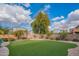 Landscaped backyard with artificial turf and a stone seating area at 3730 E Kingbird Pl, Chandler, AZ 85286