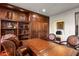 Luxurious home office boasts built-in wooden cabinetry and leather chairs at 40980 N 97Th St, Scottsdale, AZ 85262