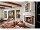 Cozy living room features a fireplace, leather seating, and wood beams at 40980 N 97Th St, Scottsdale, AZ 85262